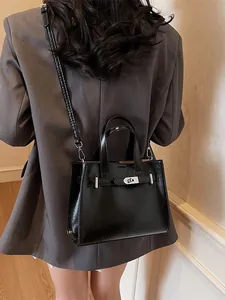 Sac à bandoulière en cuir noir brillant pour femme avec boucle argentée élégante