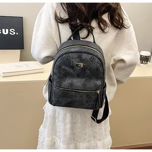 Detail view of dark grey embossed tote backpack with floral patterns and gold hardware