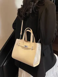 Sac à main beige minimaliste avec fermoir pivotant en métal présenté en studio