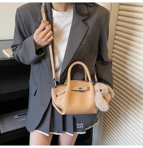 Close-up of apricot lychee pattern leather bucket bag with cute rabbit pendant