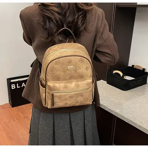 Detail of embossed clover pattern and gold logo on vintage brown faux leather backpack