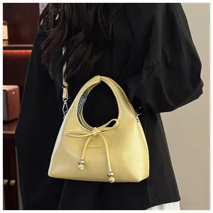 Dettaglio della borsa in pelle PU giallo chiaro con fiocco decorativo e logo in rilievo