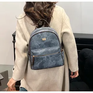 Macro shot of grey-blue textured backpack showing vintage embossed leather details