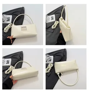 Détails du sac baguette crème avec décoration perle et étiquette de marque logo