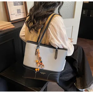 Détail d'un grand sac cabas avec lanières en cuir et pendentif en perles décoratives