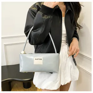 Détail du sac baguette bleu clair en similicuir avec un grand accent de perle décoratif