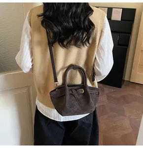 Détails du sac seau marron foncé avec coutures matelassées et boucles dorées