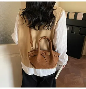 Sac bandoulière marron en daim plissé avec poignée ronde et sangle réglable sur mannequin