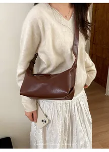 Retro minimalist dark brown faux leather baguette bag with wide shoulder strap worn by model