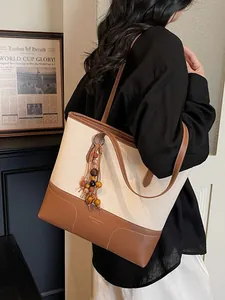 Grand sac cabas en toile beige avec bordure en cuir marron et pompon en perles de bois chic