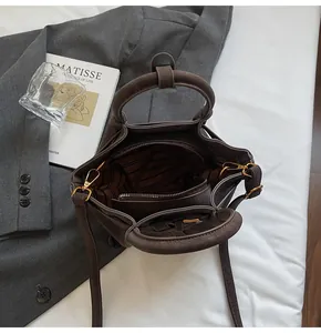 Gros plan du sac marron montrant la doublure rayée et la poche intérieure zippée