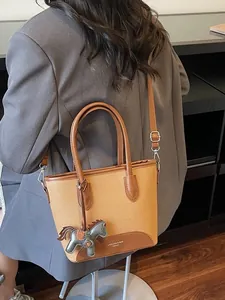 Elegante bolso de lona bicolor con asas de cuero y colgante de caballo en modelo