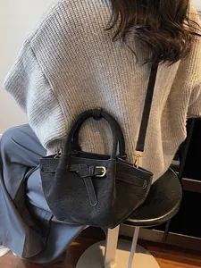 Sac seau matelassé noir minimaliste pour femme avec poignée et bandoulière élégante