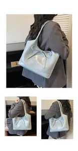 Détail du grand sac cabas bleu clair en similicuir avec nœud décoratif et logo gravé