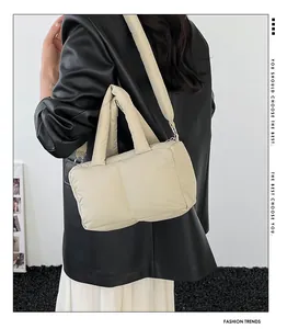 On-body view of cream puffer tote bag featuring quilted texture and wide shoulder strap