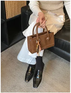 Sac baguette en cuir marron avec breloque perlée dans un cadre de style de vie décontracté