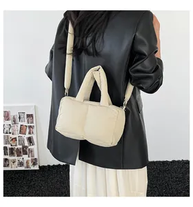 Minimalist beige quilted tote bag shown in a modern industrial setting with model