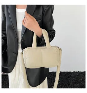 Close-up of minimalist beige quilted tote bag with soft padded shoulder strap details