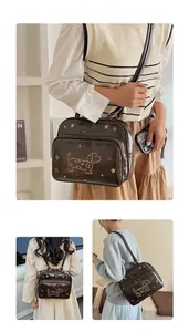 Détail du sac en cuir marron foncé brillant avec broderie de teckel et motifs d'étoiles