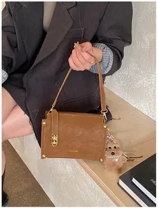 Détail du sac carré marron caramel avec pendentif ours en peluche et métal doré