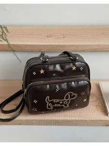 Détail du sac cabas marron café avec broderie teckel dorée et motifs d'étoiles