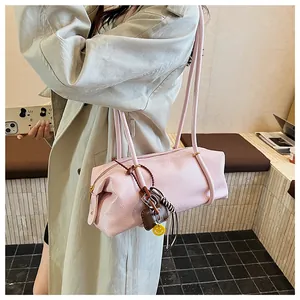 Pink pleated baguette tote bag with long double straps and a yellow smiley face charm