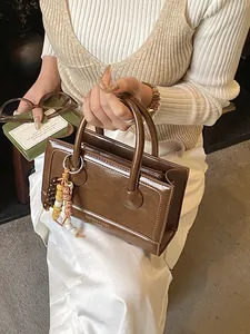 Sac baguette en similicuir marron avec doubles anses et breloque perlée bohème