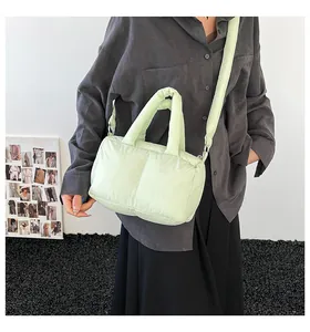 Close-up of lightweight light green quilted tote bag showing plush texture and strap detail