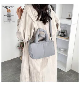Lifestyle view of the grey quilted puffer tote bag shown on a model in a minimalist room