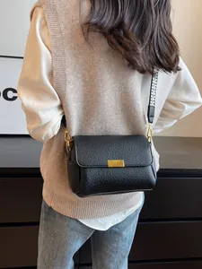 Sac baguette noir chic avec texture litchi et bandoulière tissée géométrique