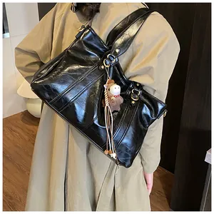 Große Vintage-Tragetasche in Schwarz mit Plüschpferd-Anhänger, von Model in Trenchcoat getragen