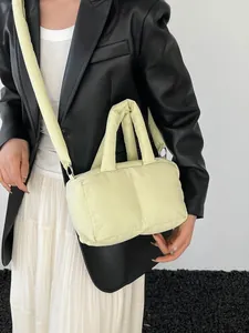 Quilted sage green tote bag with padded handles and wide shoulder strap in modern style