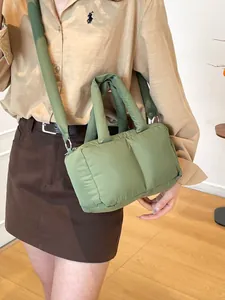 Minimalist grass green puffer tote bag with quilted texture and padded strap shown on model