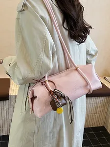 Pink minimalist tote baguette bag with charms shown from a side view on a model