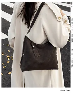 Detail of dark brown vintage faux suede tote bag worn with a chic autumn trench coat