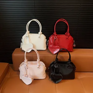 Minimalist shell-shaped handbags in four colors with heart charms and knotted handles