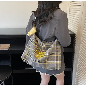Detail of yellow and gray checkered tote bag with heart embroidery and broad shoulder strap