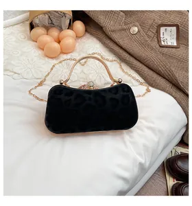 Gros plan du sac à main léopard vintage noir avec poignée dorée et détails en cristal
