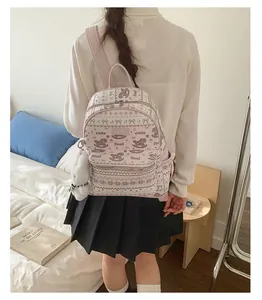 Close-up of pink foal print mini backpack with plush pom-pom charm and metal zipper