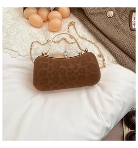 Détail du sac à main léopard en daim avec poignée dorée et boucle en strass chic