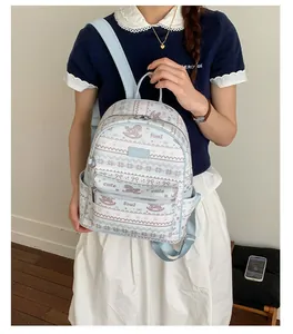 Detail of light blue mini backpack with rocking horse print on a model shoulder