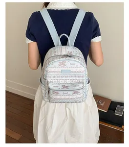 Detail of light blue printed backpack with foal patterns and adjustable shoulder straps