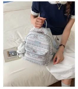 Detail of light blue printed backpack with foal patterns and white plush bunny charm