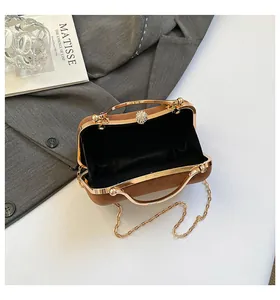 Détail du mini sac vintage en daim marron avec poignée dorée et fermoir perle