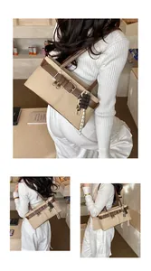 Close-up of beige canvas Boston bag with brown leather trim and chocolate charm detail