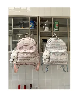 Detail of cute printed backpacks with bow patterns and plush rabbit charms on zippers