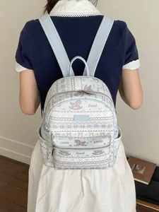 Light blue and white cartoon tote backpack shown from behind on a female model