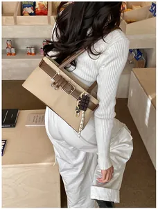 Canvas shoulder bag with brown leather trim and chocolate charm shown on model