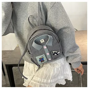 Detail of creative shirt-style backpack with blue stripes and cute bear patch
