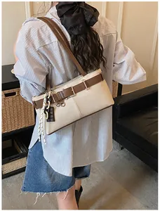 Detail view of beige canvas Boston bag with brown leather straps on a sofa